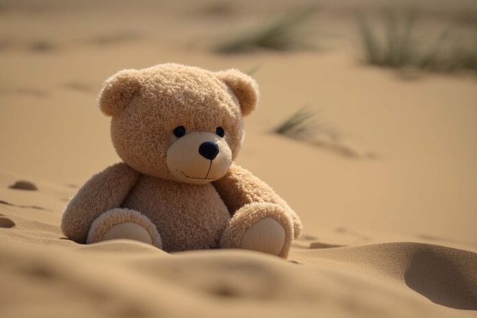 AI generated teddy bear sitting in sand.